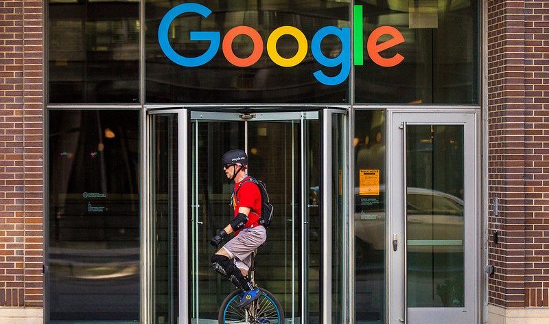 man on a unicycle in front of a Google building