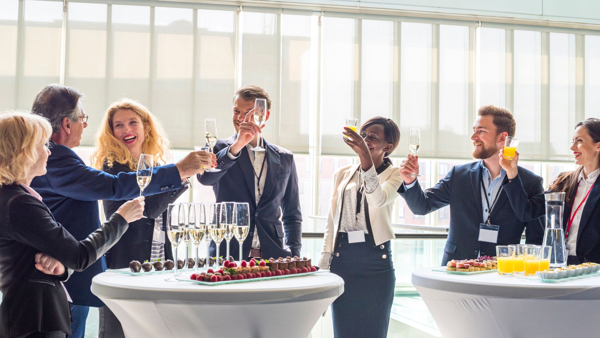 People with raised wine glasses toasting at a conference
